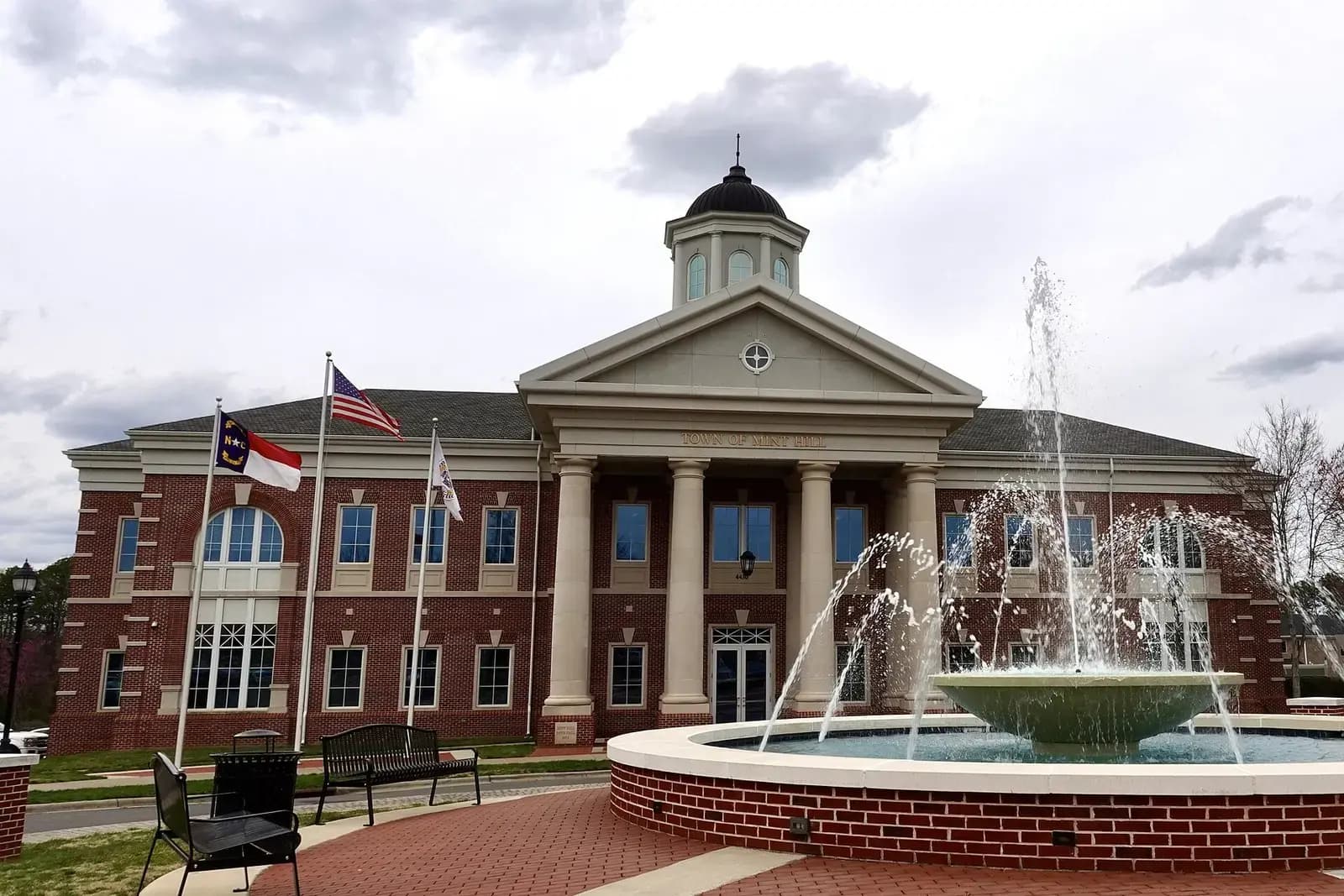 Mint Hill Town Hall with columns and a fountain in front
