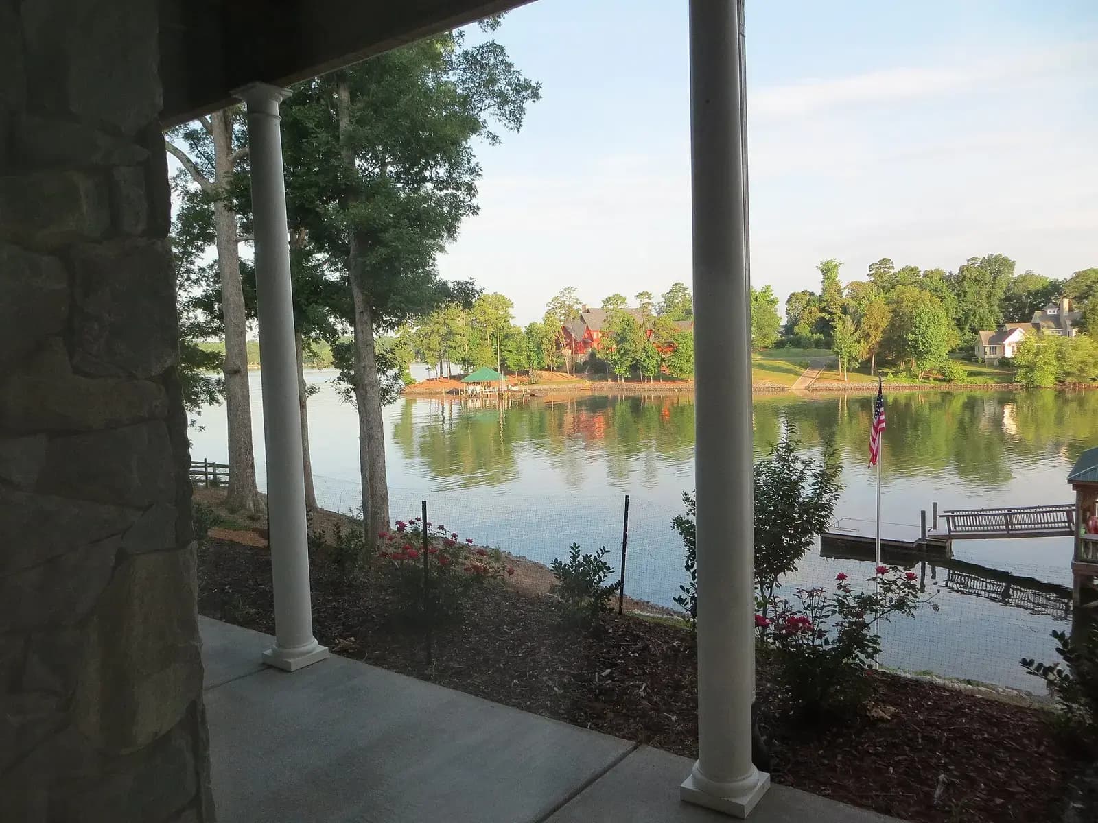 Calm Lake Wylie water and wooded shoreline seen from a covered porch