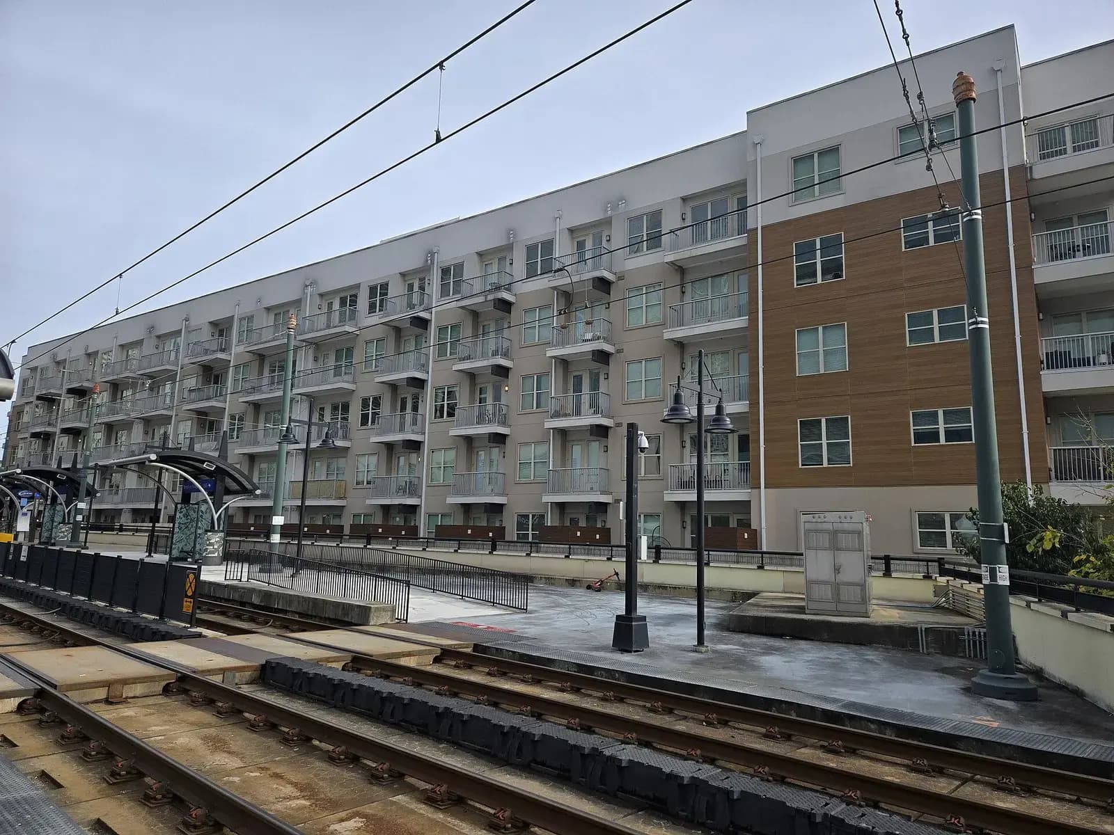 Mid-rise building beside light rail tracks near the Brooklyn Village station in Charlotte