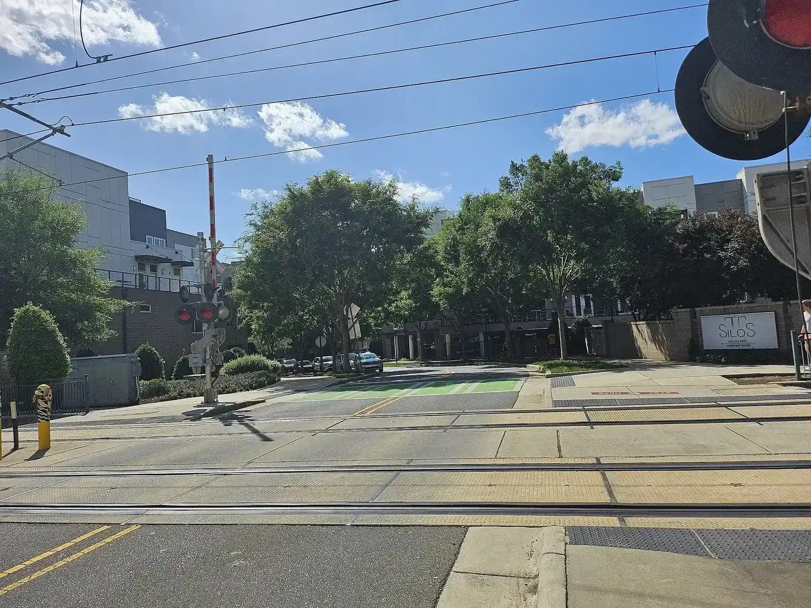 Light rail tracks crossing Poindexter Drive with new buildings beyond in Charlotte