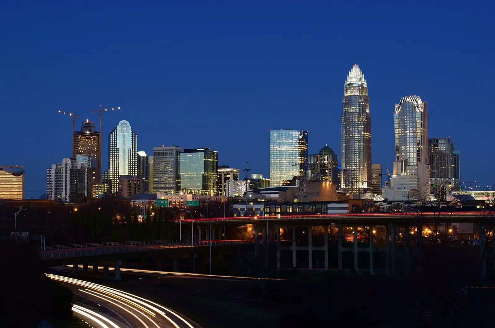 Charlotte skyline at twilight with headlight trails below