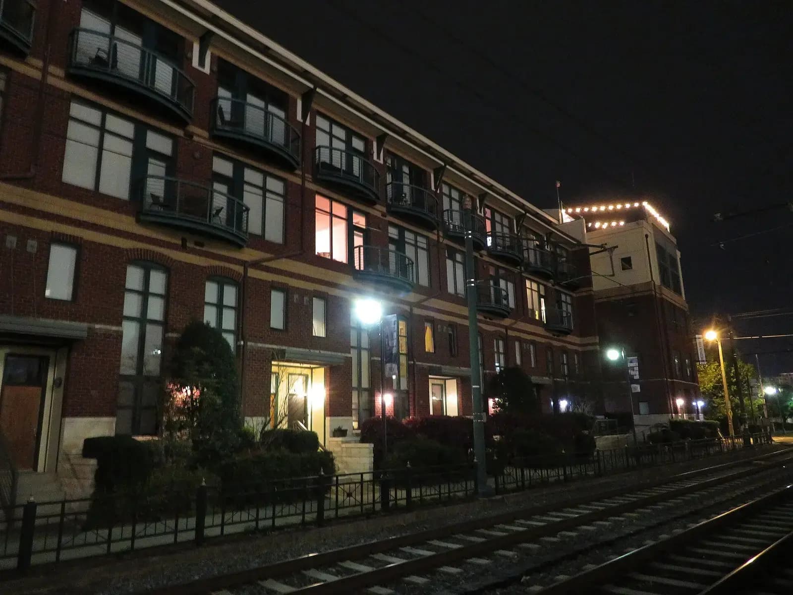 Brick mid-rise building beside the light rail at night in South End, Charlotte