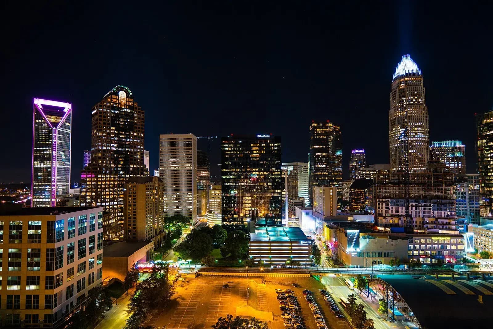 Charlotte skyline glowing at night with city lights in the foreground